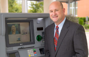 Michael Wingo of Federal Protection Inc. shows off an ITM outside Bear State Bank in Rogers.
