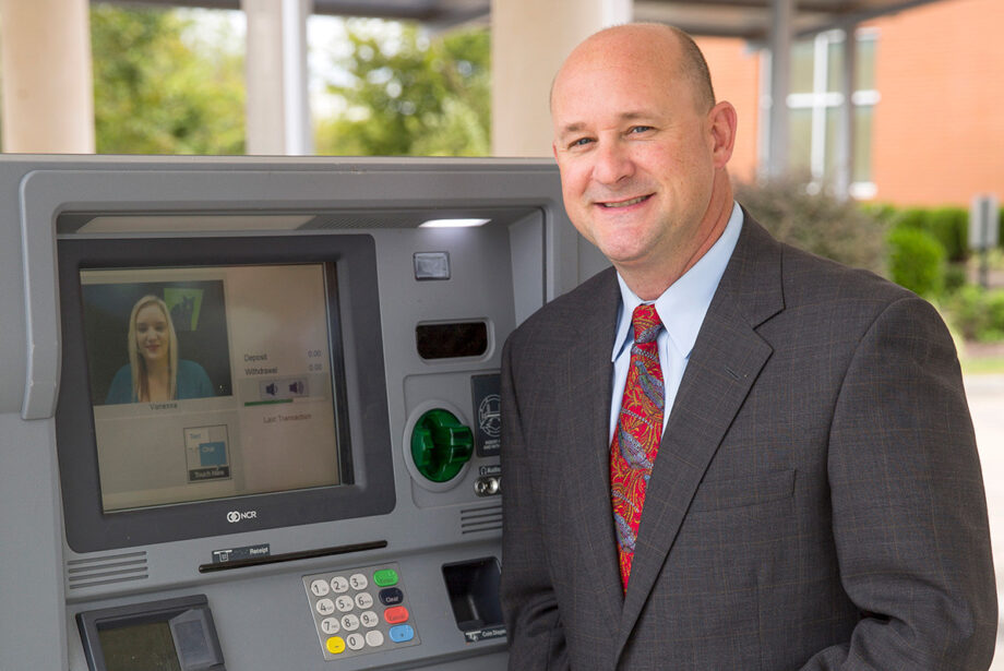 Michael Wingo of Federal Protection Inc. shows off an ITM outside Bear State Bank in Rogers.