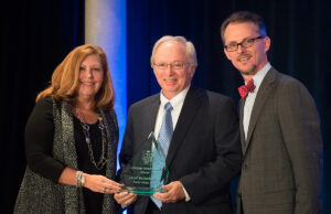 Fowler Foods CFO Lloyd McCracken Jr., center, accepts the CFO Lifetime Achievement Award from Phyllis Rogers, SVP and CFO of Delta Dental, and Mitch Bettis, publisher of Arkansas Business.