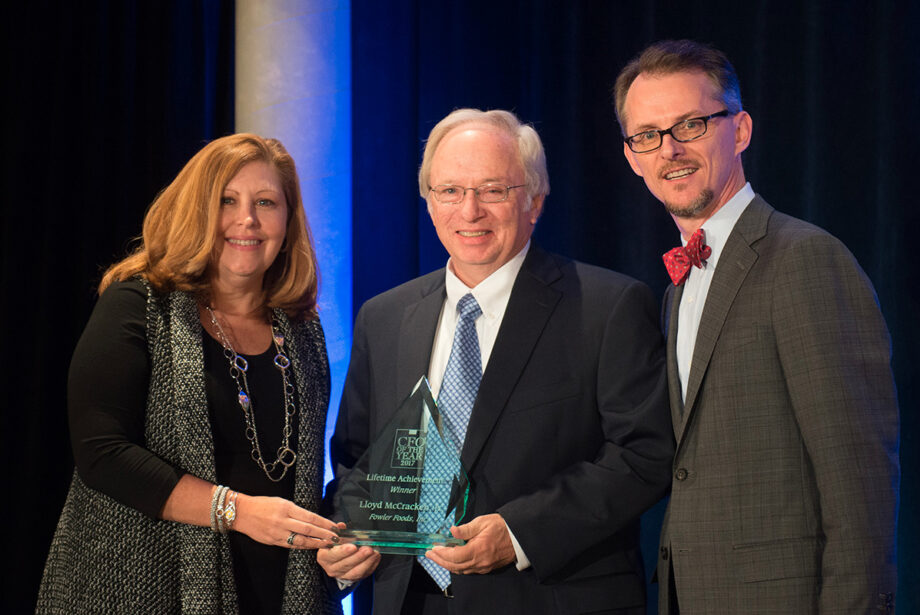 Fowler Foods CFO Lloyd McCracken Jr., center, accepts the CFO Lifetime Achievement Award from Phyllis Rogers, SVP and CFO of Delta Dental, and Mitch Bettis, publisher of Arkansas Business.