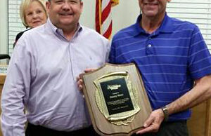 Jimmy Story (right) accepts a plaque recognizing his 20-year employment with the city of Farmington from Mayor Ernie Penn during an April 2015 city council meeting.