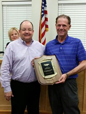 Jimmy Story (right) accepts a plaque recognizing his 20-year employment with the city of Farmington from Mayor Ernie Penn during an April 2015 city council meeting.