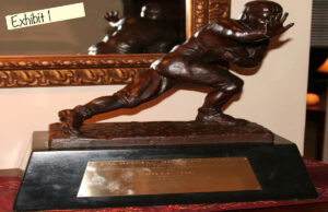 United States v. John Rogers: A sample of bogus sports memorabilia introduced as evidence in the fraud case against Rogers includes a commemorative Heisman Trophy transformed into a counterfeit 1978 Heisman Trophy awarded to Billy Sims.