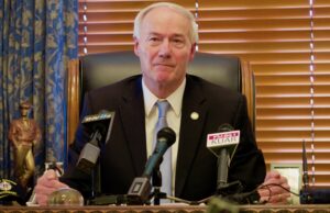 Asa Hutchinson meet with reports to talk about the reduced number of participants in the state's Medicaid program.
