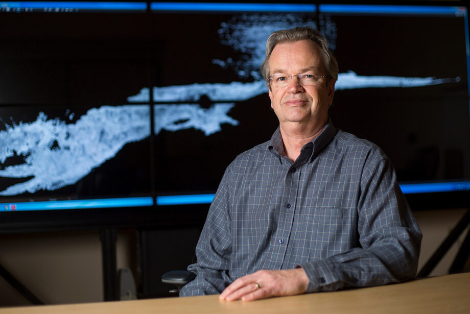 Malcolm Williamson, J. William Fulbright College of Arts & Sciences as Research Associate at the University of Arkansas, sits in front of a digital map of Carlsbad Caverns in New Mexico.