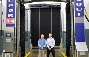 Whiting Systems Inc. President Chad Glenn (left) and former president Russ Whiting, of the family ownership group, with one of the company's large truck wash gantries.