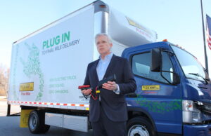 Craig Harper, chief operations officer at J.B. Hunt, shows off one of the&nbsp;five FUSO eCanter all-electric medium-duty box trucks the company has added to its private fleet.