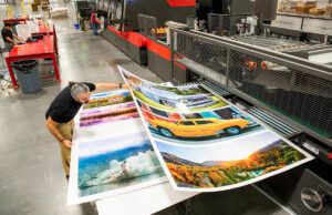 Justin Best of Precision Digital Printing of Jonesboro checks color quality from the Nozomi C18000 press.  Lamb & Associates Packaging of Maumelle has a similar cutting-edge machine.