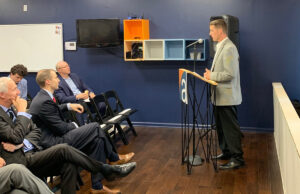 Mark Mason,&nbsp;founder and principal of Affirma Consulting, speaks at the recent grand opening of the company's Fayetteville location. Sitting on the front row is Gov. Asa Hutchinson and Arkansas Economic Development Commission Director Mike Preston.
