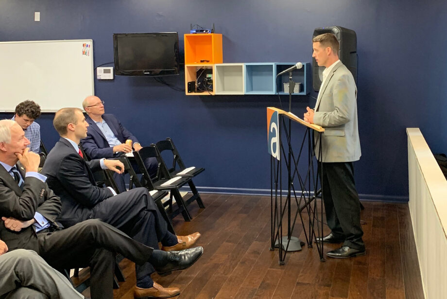 Mark Mason,&nbsp;founder and principal of Affirma Consulting, speaks at the recent grand opening of the company's Fayetteville location. Sitting on the front row is Gov. Asa Hutchinson and Arkansas Economic Development Commission Director Mike Preston.