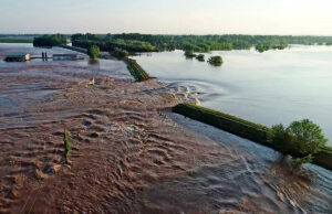 Water rushes through the levee along the Arkansas River in Dardanelle on May 31.