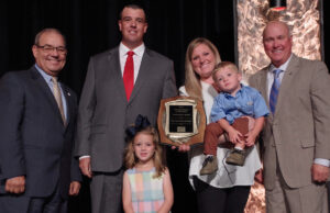 Mark and Shay Morgan (center) and their two children, Kate and Luke, with Randy Veach (left) and Vice President Rich Hillman, both of the Arkansas Farm Bureau.