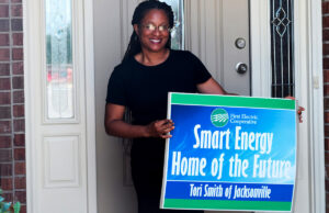 Tori Smith stands outside her Jacksonville home, which was recently updated by First Electric Cooperative with home automation technology designed to increase energy efficiency.