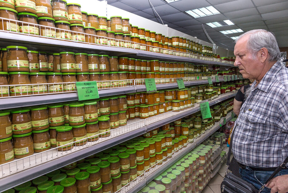 A customer surveys the wide selection of vegetable jars available inside a Ukranian supermarket.