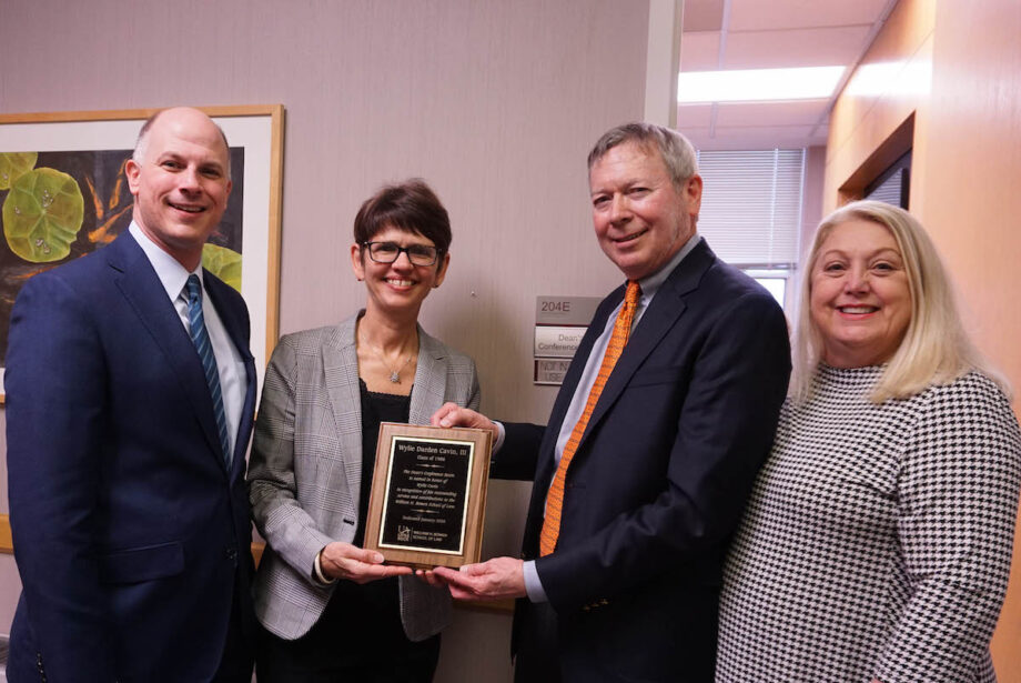 Bowen Dean Theresa Beiner (center left) presents alum Wylie Cavin III (center right) with a plague naming the Dean's Conference Room in his offer. Also pictured are Christian O'Neal (left), vice chancellor for university advancement, and Wanda Hoover (right), Bowen's assistant dean of external relations.&nbsp;&nbsp;