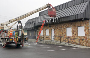 In January, workers with Arkansas Sign & Neon Co. installed a smaller sign at the Herbology medical marijuana dispensary on Kanis Road in Little Rock.