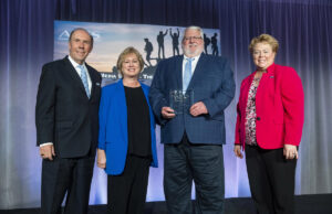 Marty Ryall, holding plaque, with APTS President Patrick Butler, left, Arkansas PBS Executive Director Courtney Pledger and Molly Phillips, executive director of Iowa PBS, right.
&nbsp;