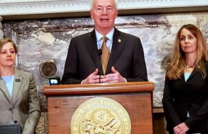 Gov. Asa Hutchinson, flanked by Marcy Doderer, CEO of Arkansas Children's (left), and state Sen. Missy Irvin, R-Mountain View.