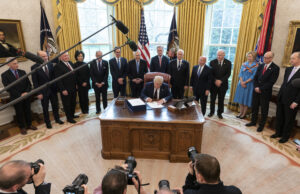 President Donald Trump, surrounded by federal health officials and Republican lawmakers, signed the&nbsp;Coronavirus Aid, Relief & Economic Security (CARES) Act on Friday.