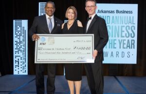 Angela McGraw, executive director of Women & Children First: The Center Against Family Violence in Little Rock, with AT&T Arkansas President Ronnie Dedman (left) and Arkansas Business Publisher Mitch Bettis after winning the Nonprofit Organization of the Year award.