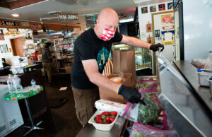 Kevin Hamman with operations and catering at The Root Cafe in Little Rock packs up locally sourced grocery items for a  delivery.