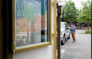 Justin Hurty, general manager at The Root Cafe in Little Rock delivers a curbside order to a customer.