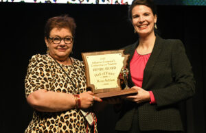 Renee Robison, left, accepts her induction award into the Arkansas Tourism Hall of Fame from Deputy Tourism Director Kristine Puckett