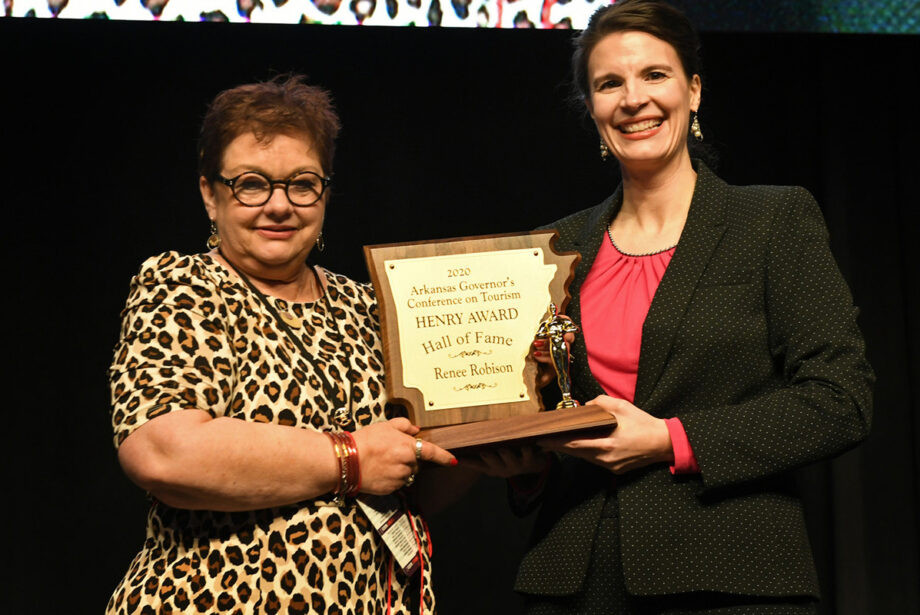 Renee Robison, left, accepts her induction award into the Arkansas Tourism Hall of Fame from Deputy Tourism Director Kristine Puckett