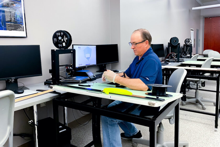 UAFS' Derek Goodson uses a 3-D printer to make a face shield component.