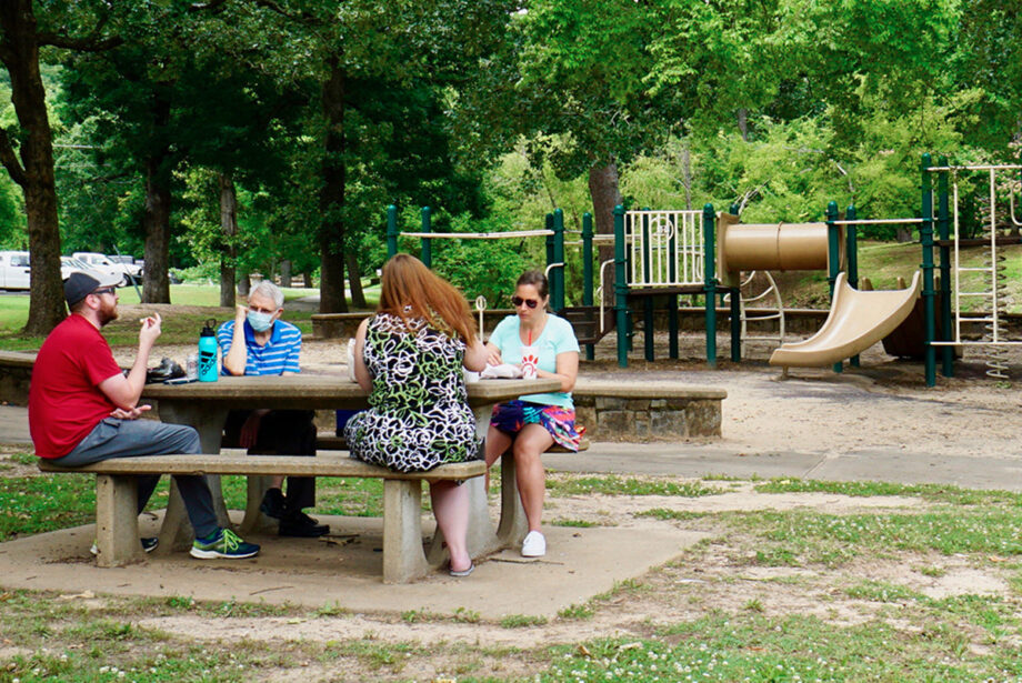 Picnickers enjoyed lunch last week in Allsopp Park while a nearby playground went unused. Park playgrounds in Little Rock, closed for most of the spring, were reopened on Friday.