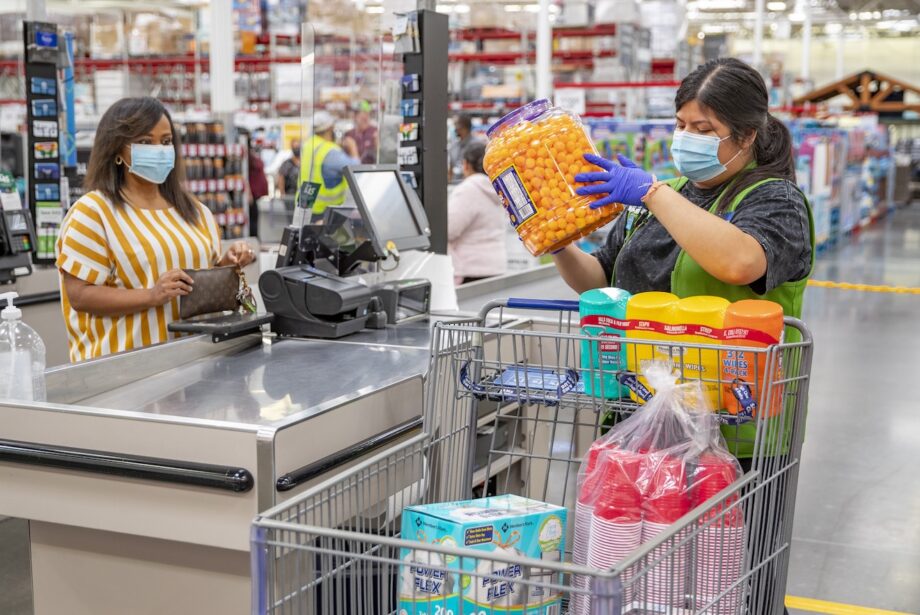 A Sam's Club customer and employee wear masks inside a store. Walmart Inc. of Bentonville says it will require customers to wear masks in all its stores and clubs across the country.