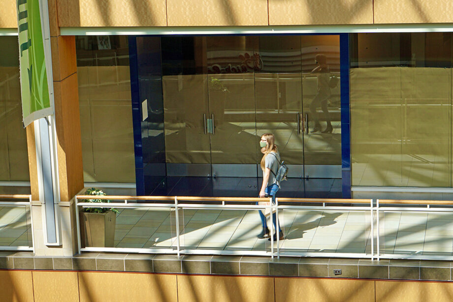 A lone shopper crosses a section of closed shops at Park Plaza in Little Rock.