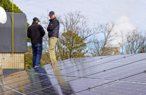 John Ekdahl of AEV Solar of Little Rock with a homeowner and client for a residential array in London (Pope County). Entergy&rsquo;s Arkansas Nuclear One is visible in the background.