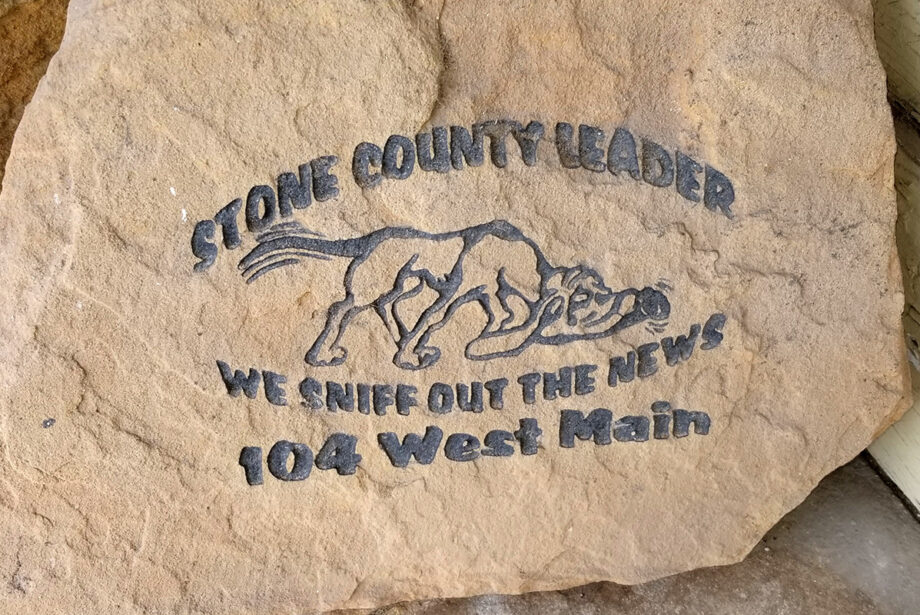 An engraved stone in a doorway on Main Street in Mountain View advertises the Stone County Leader.