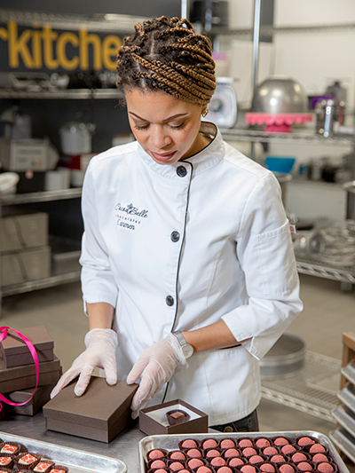 Carmen Portillo, owner of Cocoa Bella Chocolates, packages chocolate truffles at Arkitchen in Little Rock.