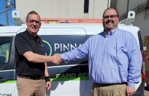 Chris Bates, CEO of The Computer Hut (right), shakes hands with Bill Stuckey, president of Pinnacle IT.