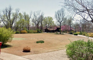 A putting green can be seen partially obscured in the front yard of the former home of Frank and Barbara Broyles in Fayetteville.
