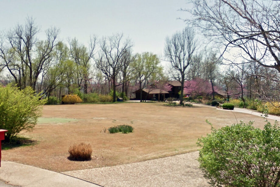 A putting green can be seen partially obscured in the front yard of the former home of Frank and Barbara Broyles in Fayetteville.
