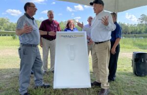 Hampton Schools Superintendent Doug Worley, left, and Ouachita Electric CEO and General Manager Mark Cayce, gesture after flipping a large display switch Wednesday to signify that the school district's new solar array is operable.