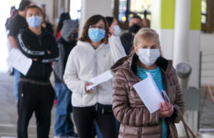 People wait in line for the new one-shot Johnson and Johnson COVID-19 vaccine at a vaccination site in Covina, California, on March 13, 2021.
