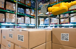 A group of boxes and an automated robotic arm in a storehouse.&nbsp;