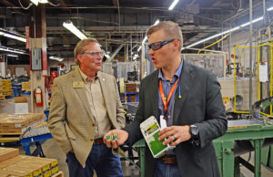 Retired employee state Rep. Roger Lynch speaks with Vista Outdoor spokesman Joel Hodgdon during a tour of the Remington plant in Lonoke.
