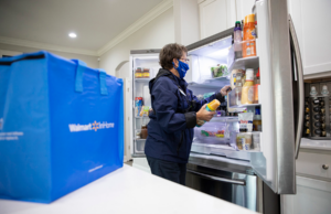 A Walmart employee places groceries in a customer's fridge as part of the company's InHome delivery service.&nbsp;
