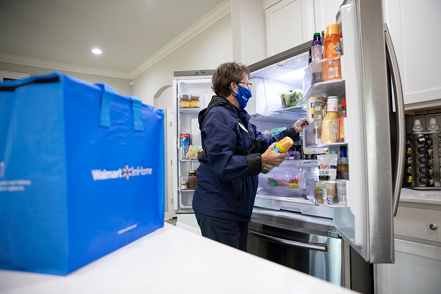 A Walmart employee places groceries in a customer's fridge as part of the company's InHome delivery service.&nbsp;