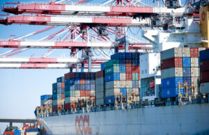 Cranes hovering over cargo on a container ship at the Port of Long Beach