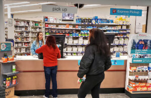 Customers wait for service at a Walgreens pharmacy.