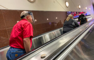 A man wearing a face shield as he rides an escalator at Hartsfield-Jackson International Airport in Atlanta, Georgia.