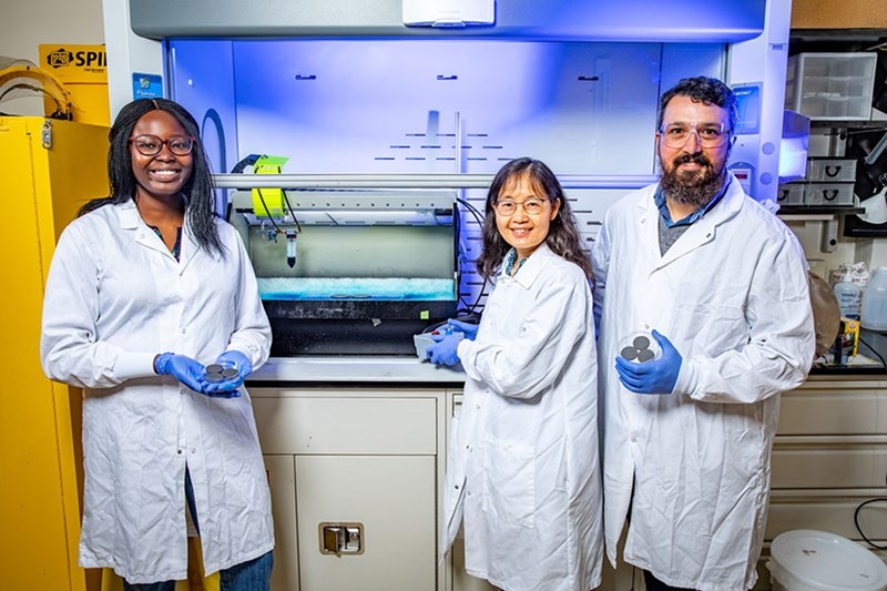 University of Arkansas doctoral student Adedoyin Abe, left, stands next to professor of mechanical engineering Min Zou and senior research assistant Josh Goss.
