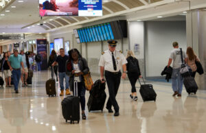 Travelers walk along a concourse at Atlanta Hartsfield-Jackson International Airport in 2019
