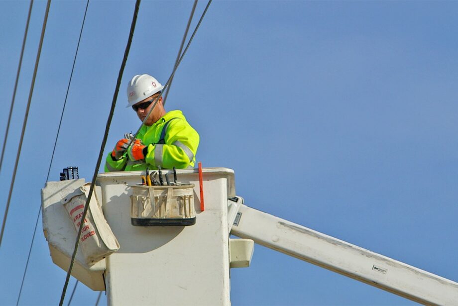 A lineman strings high-speed cable.